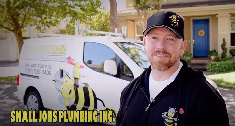 Small Jobs Plumbing technician with branded van in background