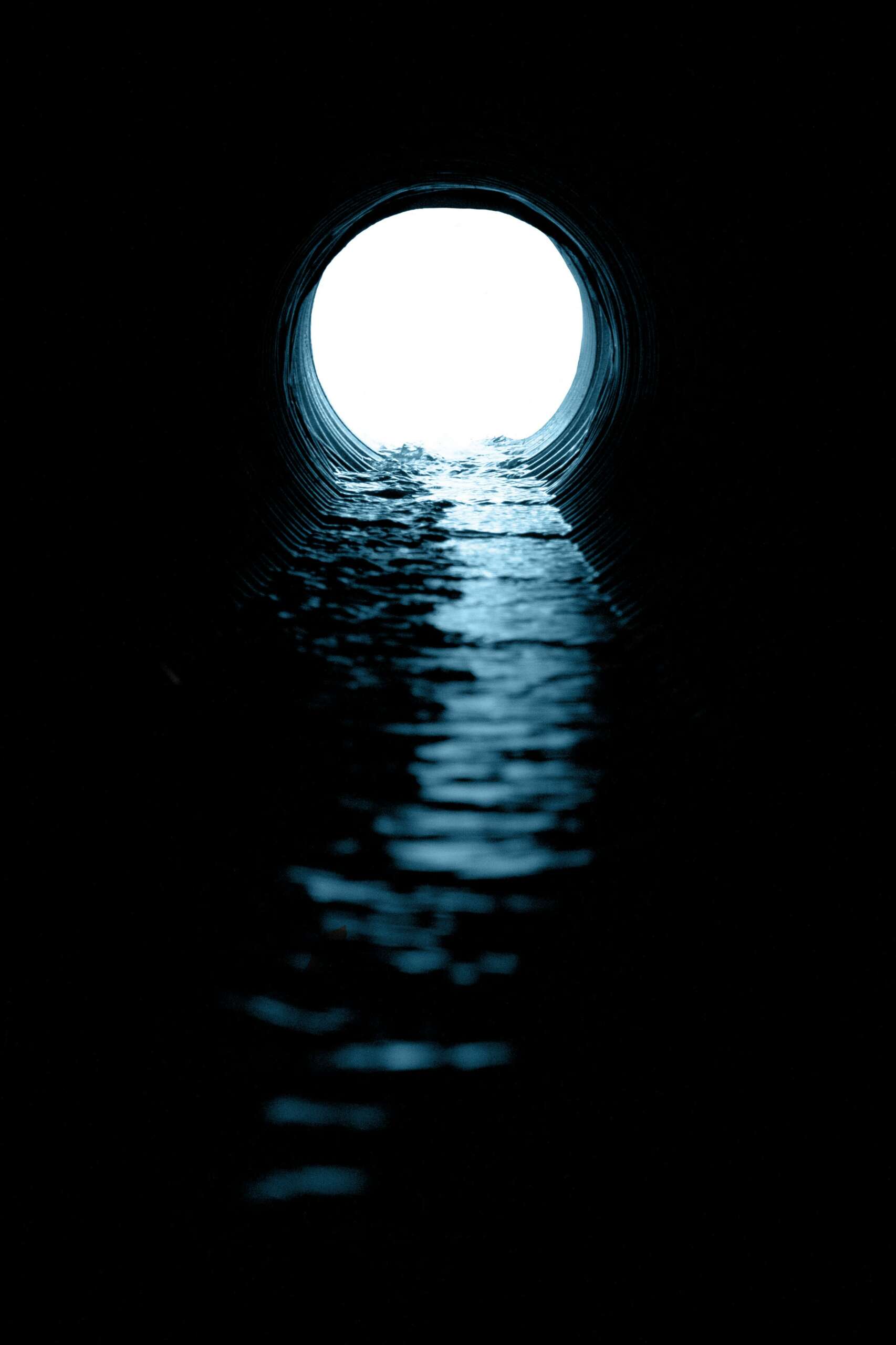 black and white tunnel of water flowing into the light