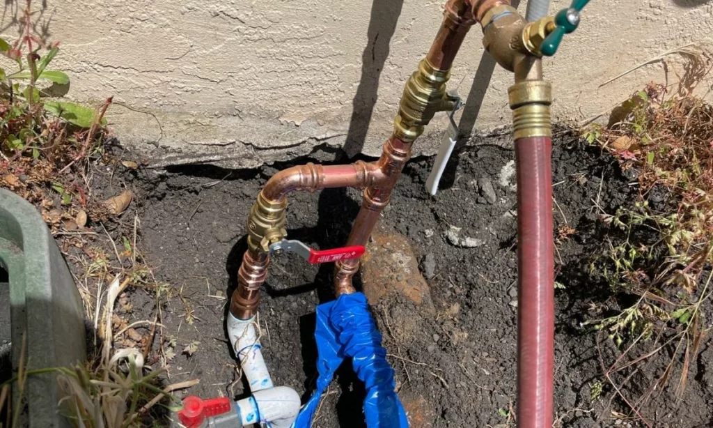 Copper water lines on the exterior of the house with a pvp connection attached to it